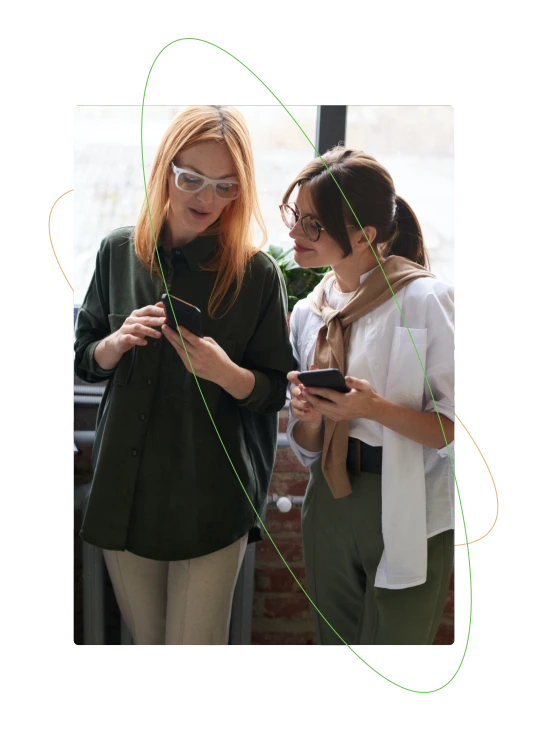 two women talking while using smartphones